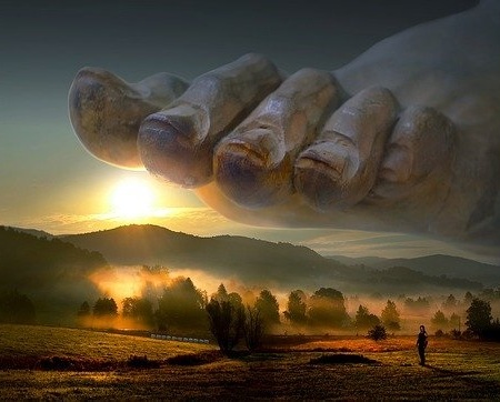 A giant foot with toenails about to stamp on idyllic countryside