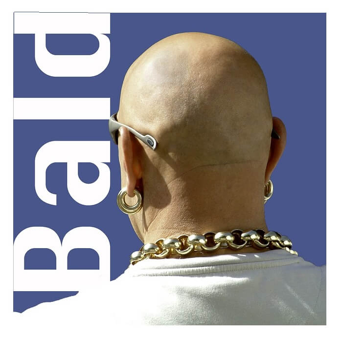 A bald man with a gold chain around his neck.